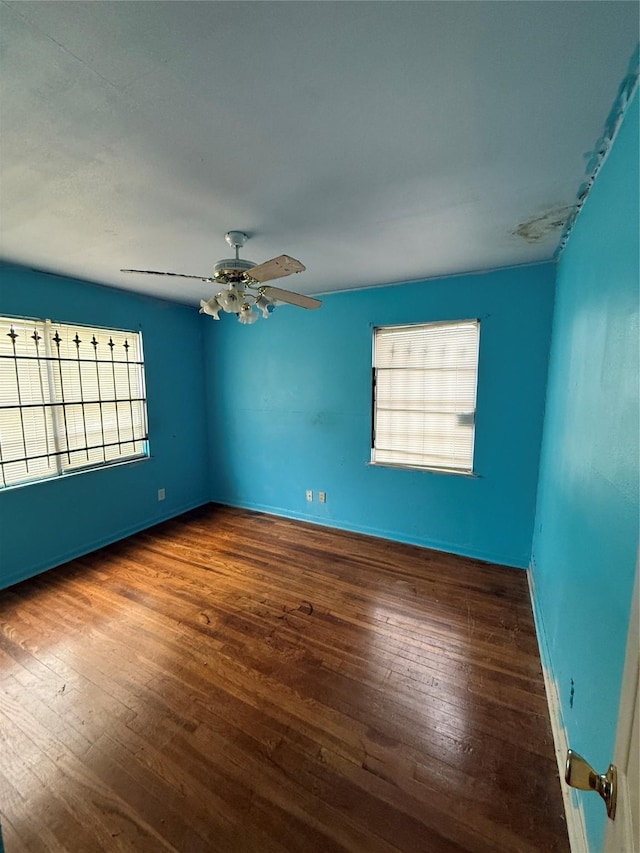 unfurnished room with ceiling fan and dark hardwood / wood-style flooring