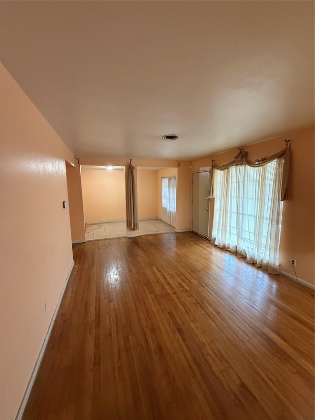 unfurnished living room with a healthy amount of sunlight and hardwood / wood-style flooring