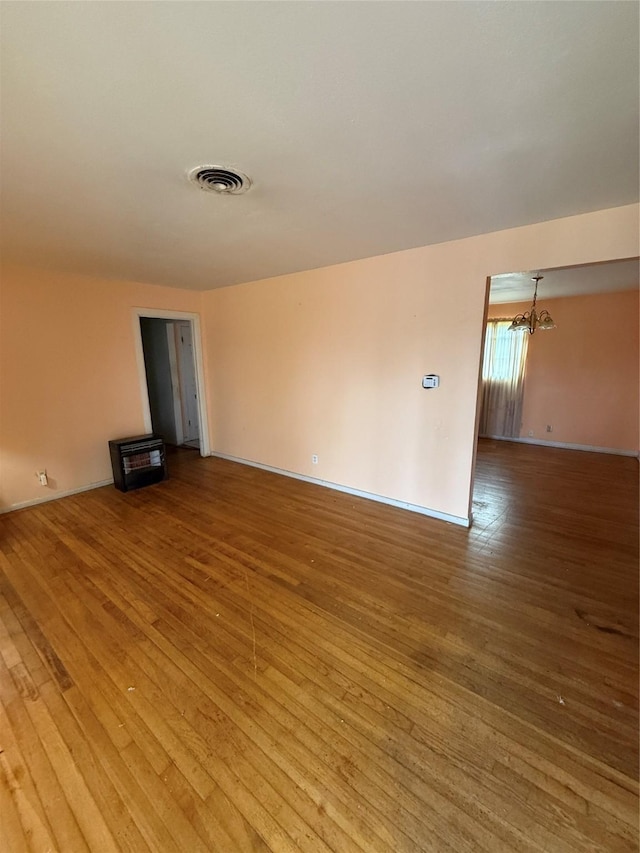 unfurnished living room with hardwood / wood-style flooring and a notable chandelier