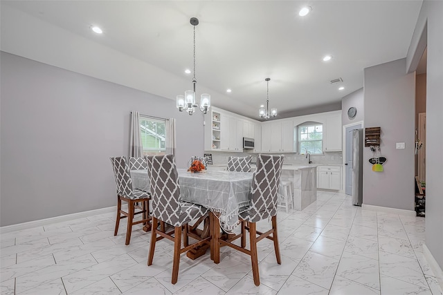 dining space with an inviting chandelier, a wealth of natural light, and sink