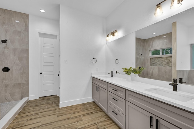 bathroom featuring tiled shower and vanity