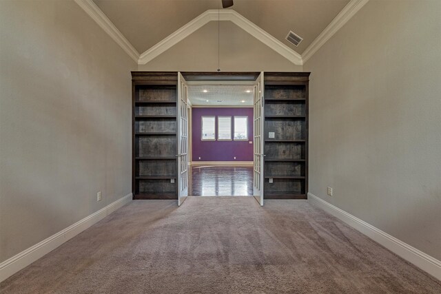 spare room with vaulted ceiling, carpet floors, and ornamental molding