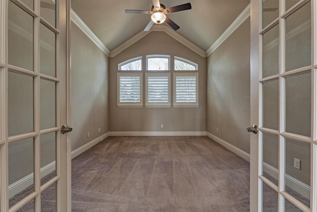 carpeted spare room with lofted ceiling, french doors, crown molding, and baseboards