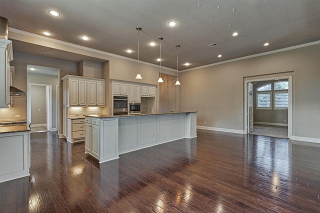 kitchen featuring dark wood-style flooring, crown molding, a large island, tasteful backsplash, and baseboards