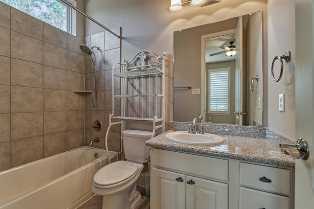 full bathroom featuring ceiling fan, vanity, toilet, and tiled shower / bath combo