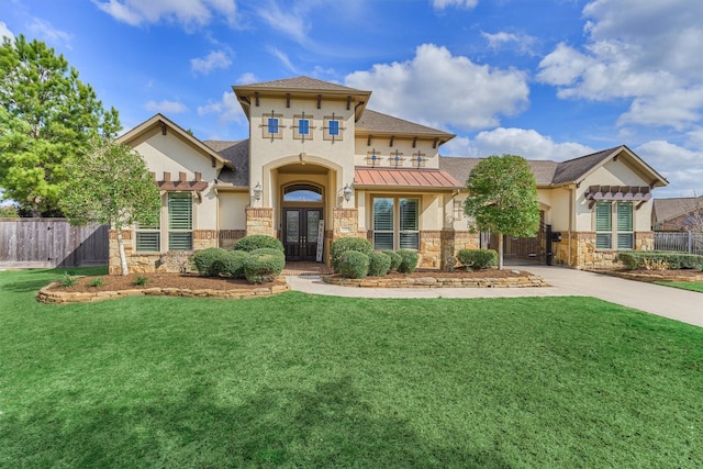 mediterranean / spanish-style house featuring a front lawn and french doors