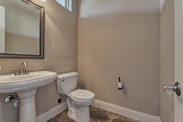 half bathroom with toilet and baseboards