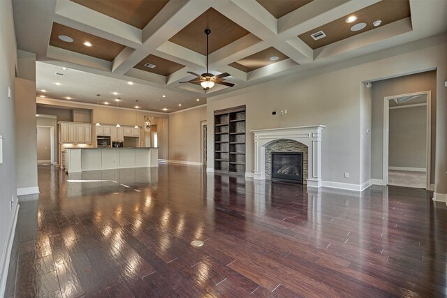 unfurnished living room with coffered ceiling, a stone fireplace, dark wood-type flooring, and ceiling fan