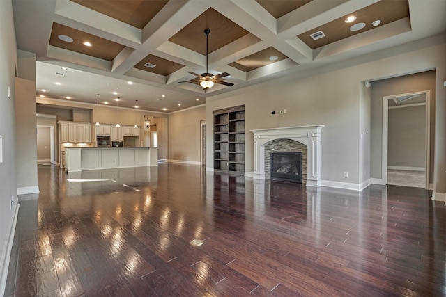 unfurnished living room with visible vents, a stone fireplace, wood finished floors, coffered ceiling, and baseboards