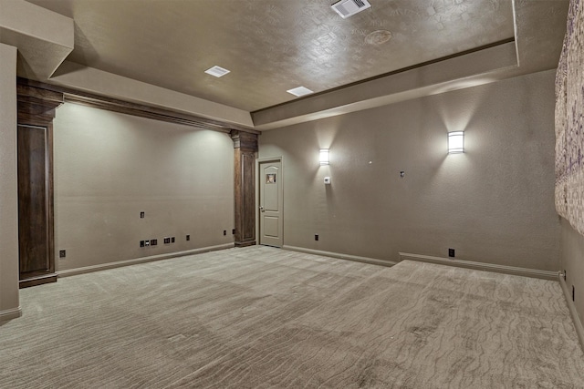 interior space with a tray ceiling, decorative columns, visible vents, and baseboards