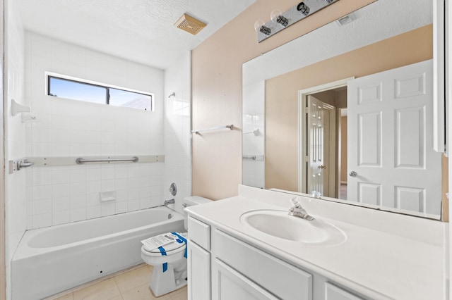 full bathroom with vanity, a textured ceiling, tile patterned flooring, toilet, and tiled shower / bath