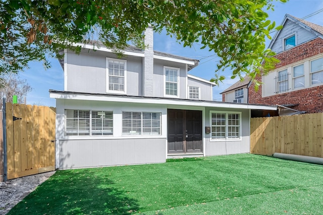 rear view of house featuring a yard