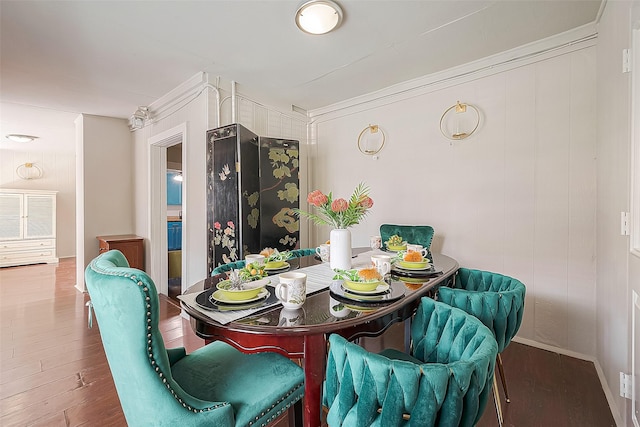 dining area with hardwood / wood-style floors and ornamental molding