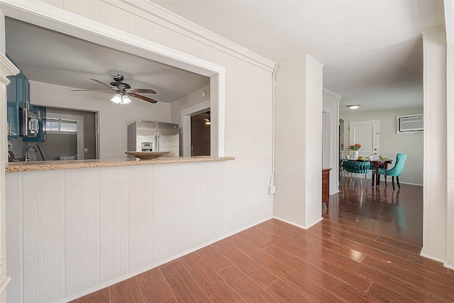 interior space with stainless steel appliances, dark hardwood / wood-style floors, ornamental molding, and ceiling fan