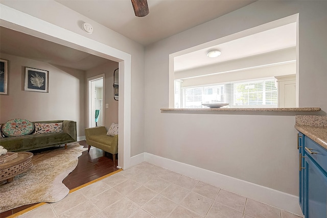 sitting room with ceiling fan and light tile patterned floors