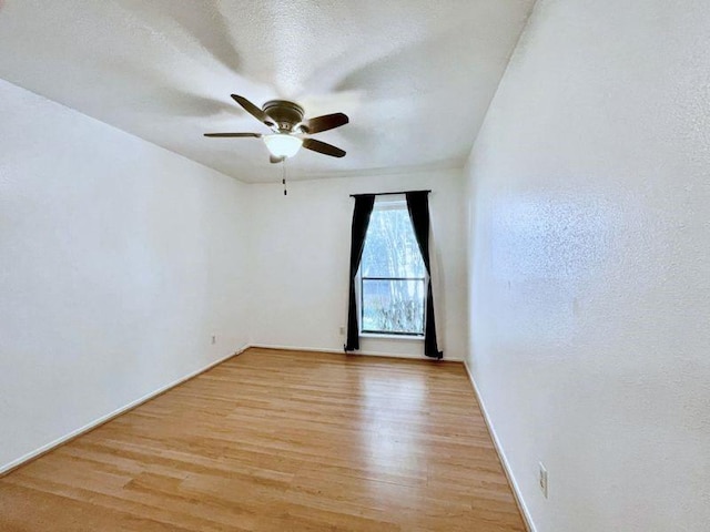 spare room with a textured ceiling, light hardwood / wood-style flooring, and ceiling fan