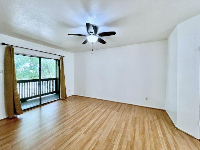 empty room with a textured ceiling, light wood-type flooring, and ceiling fan