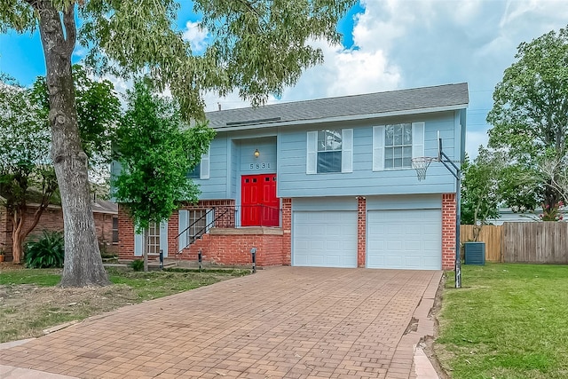 bi-level home featuring a front yard and a garage