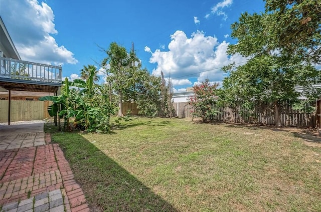 view of yard featuring a wooden deck and a patio