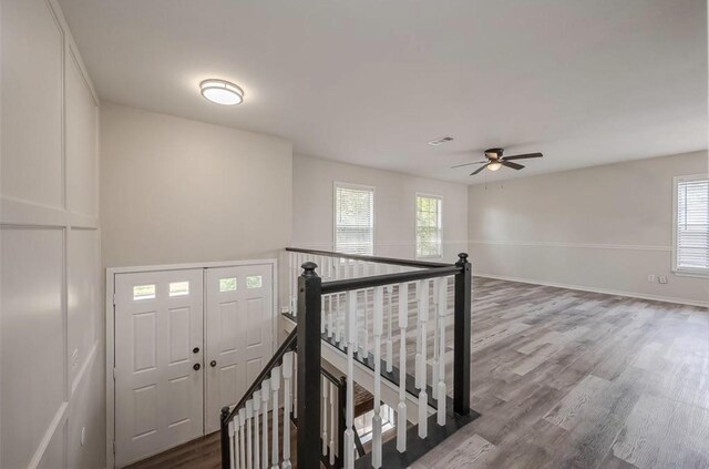 staircase with ceiling fan and wood-type flooring