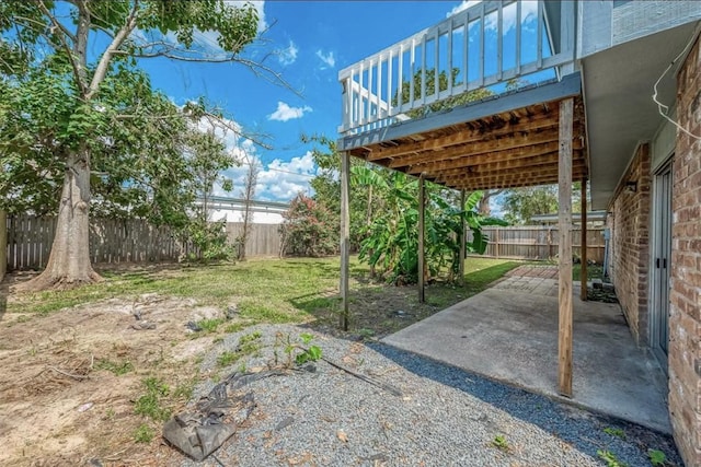 view of yard featuring a deck and a patio