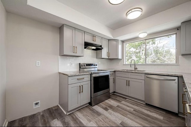 kitchen with gray cabinetry, sink, appliances with stainless steel finishes, and hardwood / wood-style floors