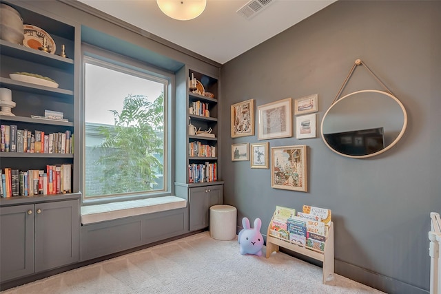 recreation room with light carpet, built in shelves, and a wealth of natural light