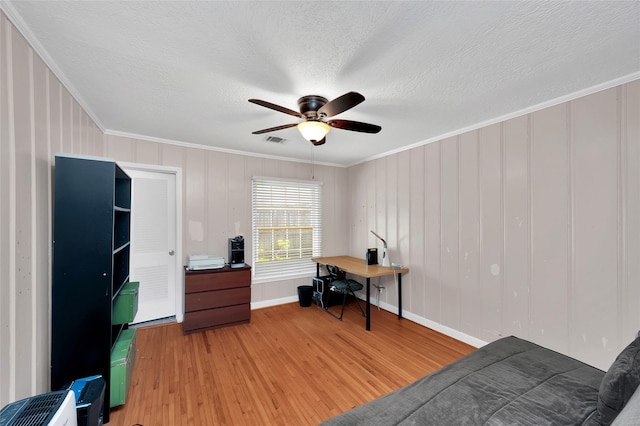 office space featuring ceiling fan, hardwood / wood-style floors, a textured ceiling, and ornamental molding