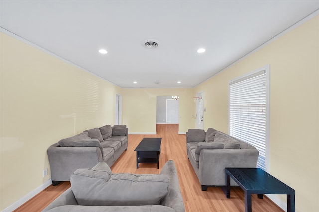 living room featuring crown molding and light hardwood / wood-style flooring