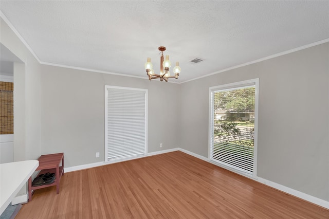 unfurnished room featuring hardwood / wood-style floors, a chandelier, and ornamental molding