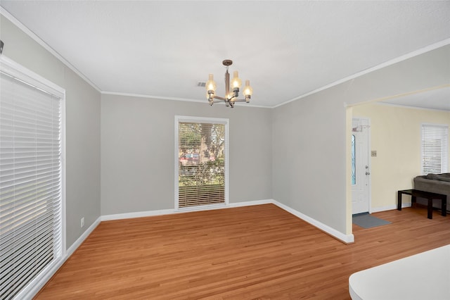 dining room featuring light hardwood / wood-style floors, ornamental molding, and an inviting chandelier