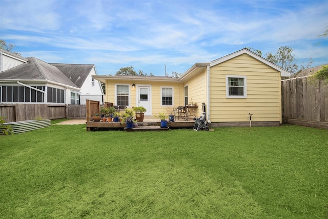 back of house with a deck and a lawn