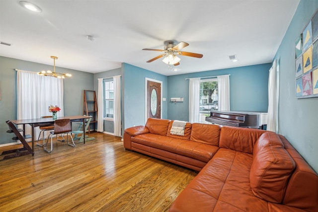 living room with light hardwood / wood-style flooring and ceiling fan with notable chandelier