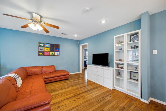 living room with ceiling fan and light hardwood / wood-style floors