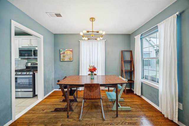 dining room featuring wood-type flooring and a notable chandelier