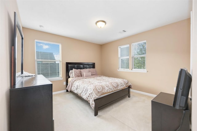 carpeted bedroom featuring multiple windows