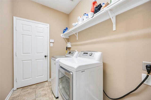 laundry room with washer and dryer and light tile patterned floors