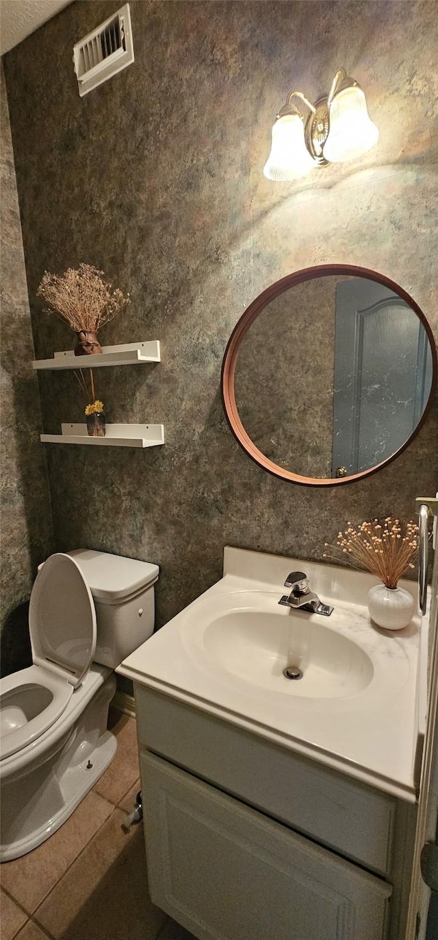 bathroom with tile patterned flooring, vanity, and toilet