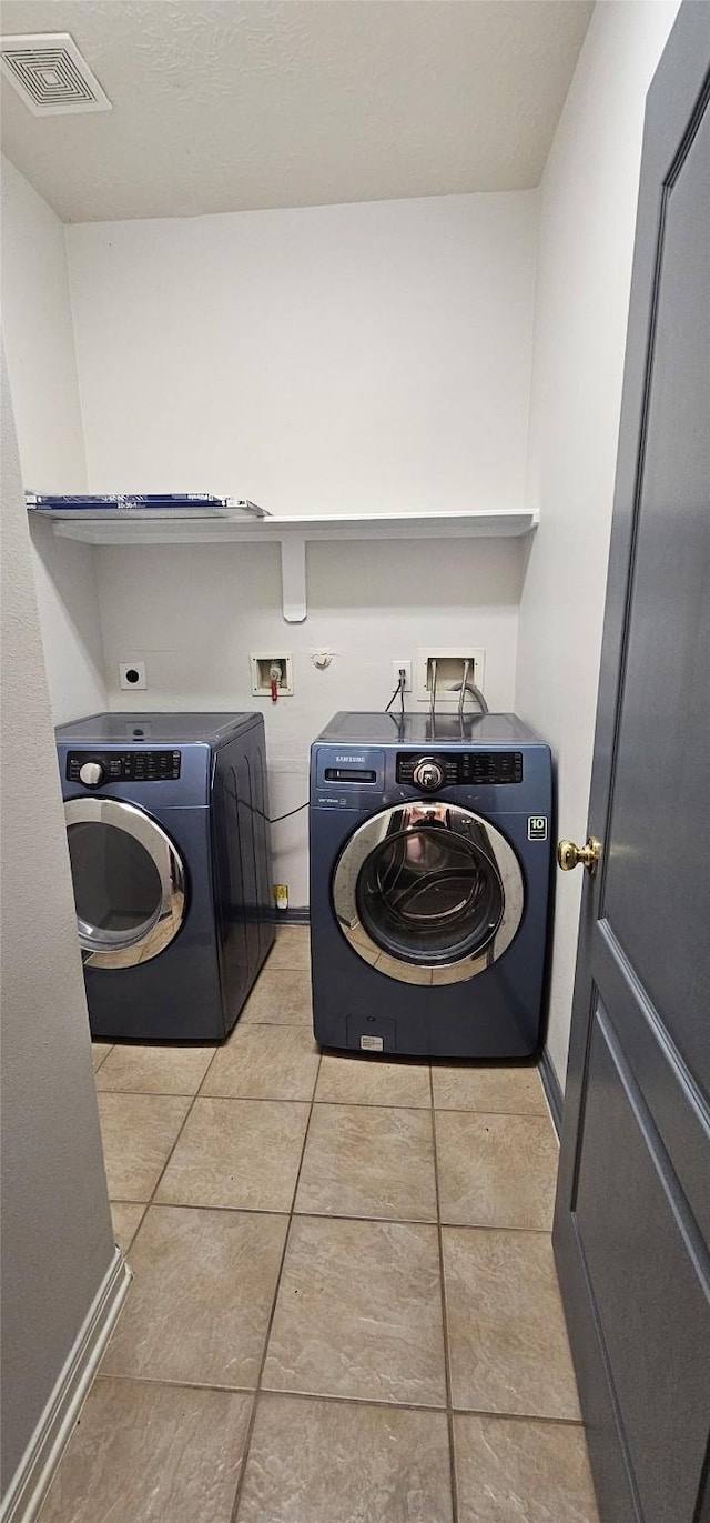 washroom featuring separate washer and dryer and light tile patterned flooring