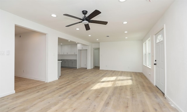 unfurnished living room with light hardwood / wood-style flooring and ceiling fan