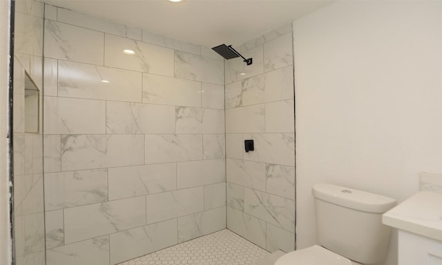 bathroom with vanity, toilet, and a tile shower