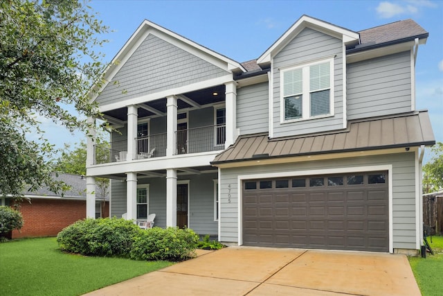 view of front of property featuring a balcony, a front lawn, and a garage