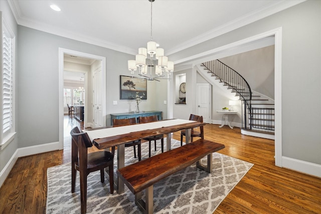 dining room featuring ornamental molding, an inviting chandelier, and dark wood-type flooring