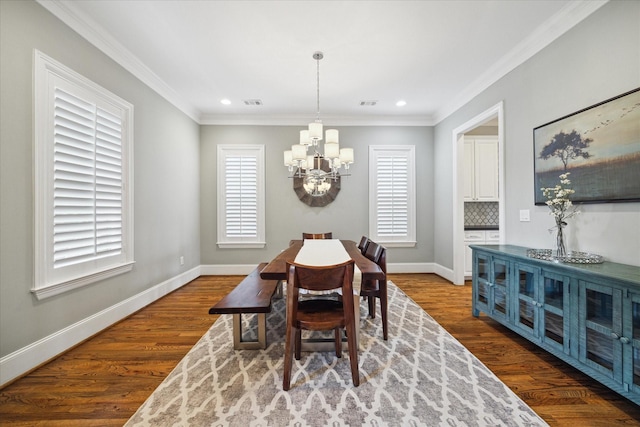 dining area featuring crown molding, hardwood / wood-style floors, and a notable chandelier