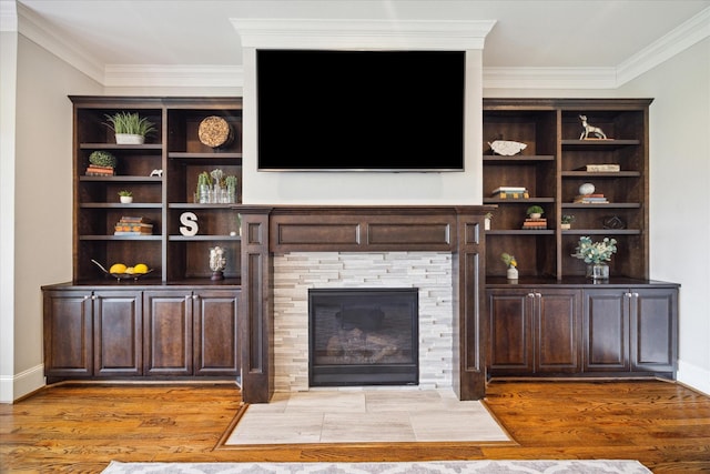 unfurnished living room featuring wood-type flooring, a fireplace, and ornamental molding