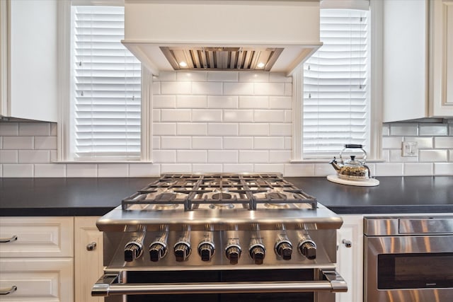 kitchen with backsplash, stainless steel oven, custom exhaust hood, white cabinets, and range