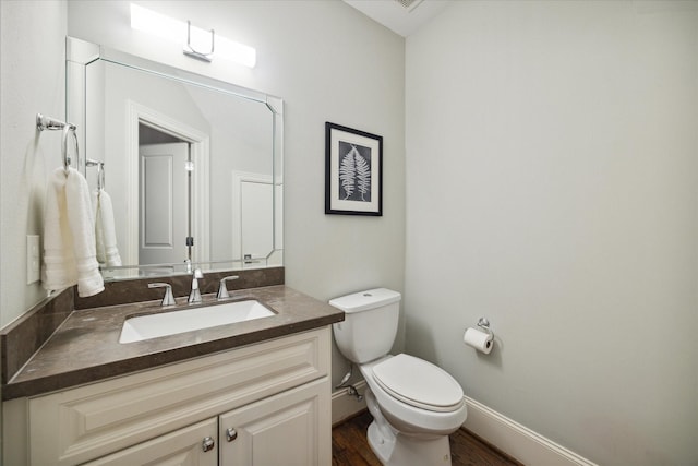 bathroom with hardwood / wood-style flooring, vanity, and toilet