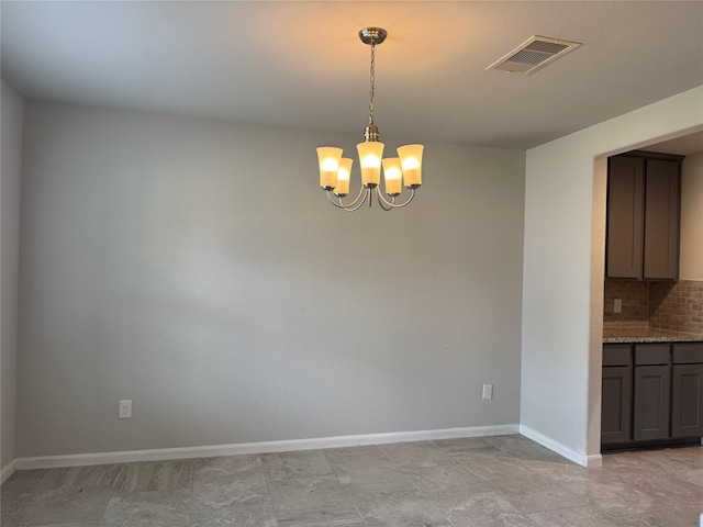 unfurnished dining area featuring a notable chandelier