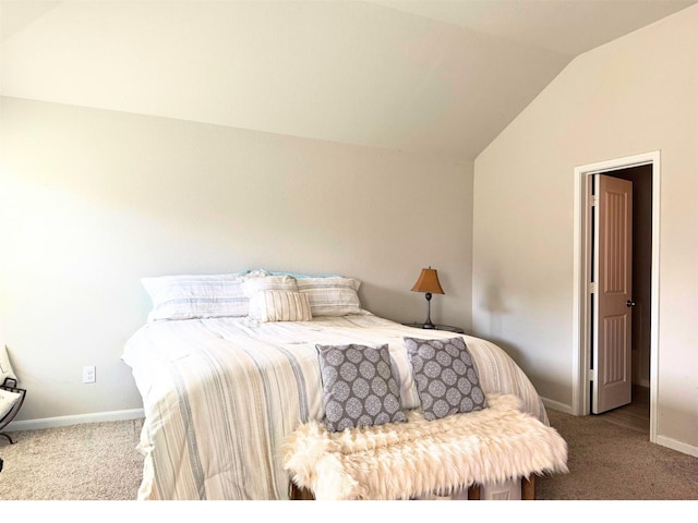 bedroom featuring lofted ceiling, light carpet, and baseboards