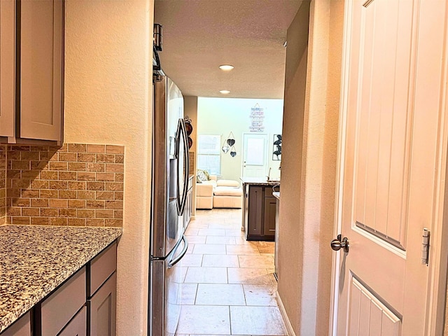 interior space featuring light tile patterned floors, a textured wall, and recessed lighting